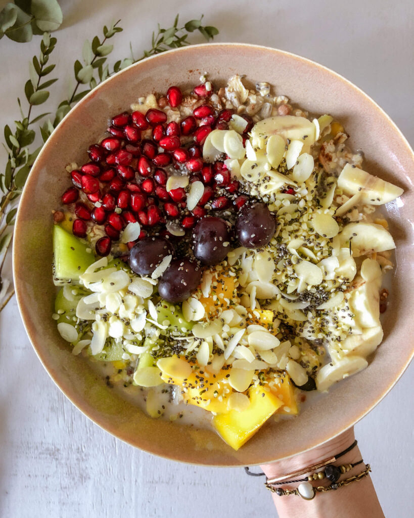 Müsli mit Trauben, Granatapfel, Kiwi, Mango, Banane, Chiasamen, Mandeln, Hanfsamen 