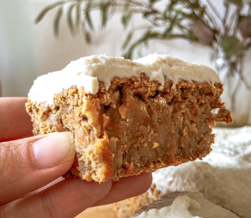 ein Stück Carrot Cake in einer Hand gehalten