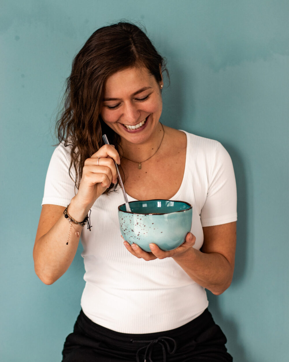 lachende Frau mit blauer Schüssel in der Hand
