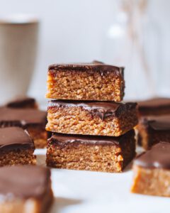 3 vegane, raw Cashew-Erdnuss-Riegel mit Schokolade als Turm aufgebaut