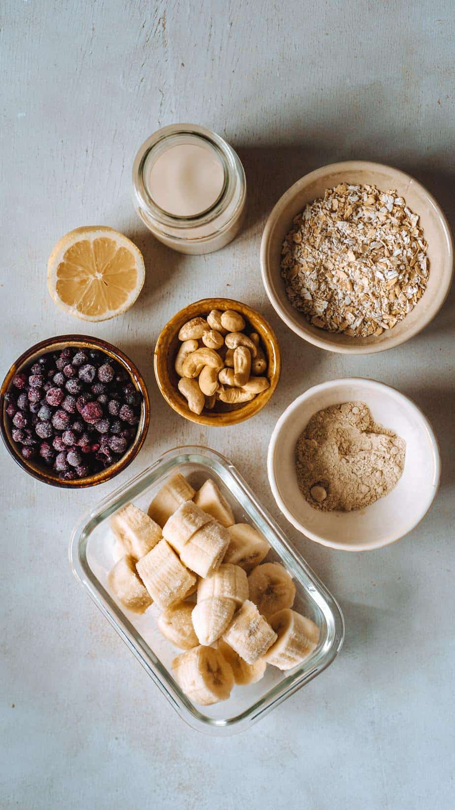 Zutaten: Haferflocken, gefrorene Heidelbeeren, gefrorene Banane, Cashews, Zitrone, Proteinpulver, Haferdrink