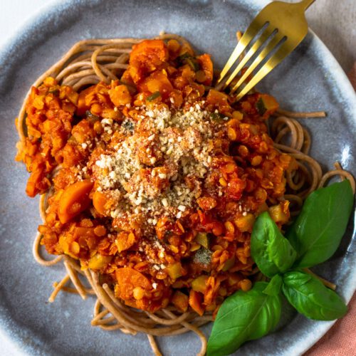 Teller mit Pasta und Bolognese aus roten Linsen von oben